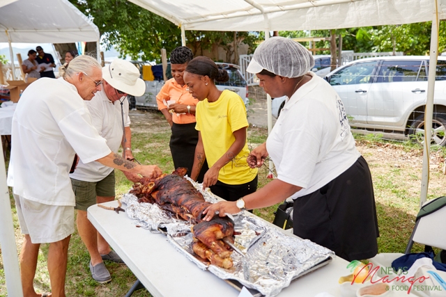 Owner of The Hermitage Plantation Inn Richard “Luppi” Lupinacci and members of his staff preparing the mango infused whole roast pig at the Nevis Tourism Authority’s Nevisian Chef Mango Feast at Oualie Beach on July 07, 2017 (photo courtesy the Nevis Tourism Authority)